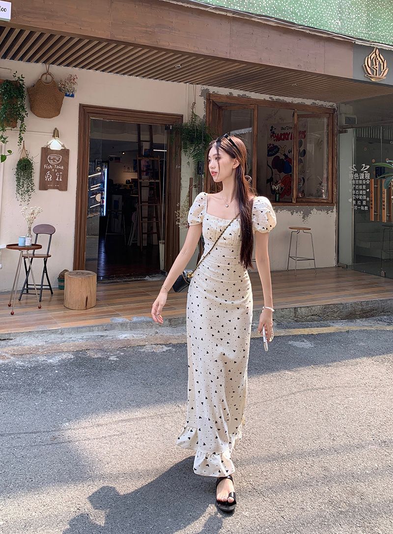 Elegant and versatile, this long, elegant tea dress features a French square neckline with pleats and tie details, and puff sleeves. Perfect for summer.