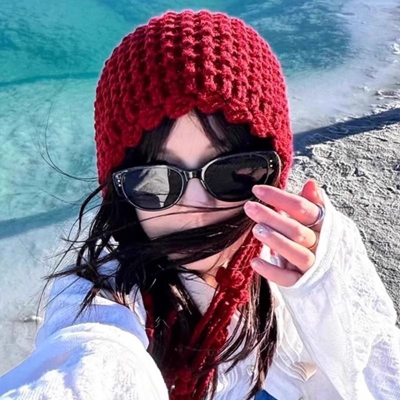 A woman wearing a woolen hat with a Sichuan Western atmosphere, a travel hat with a high-end look, and a red Xinjiang grassland knitted cold hat